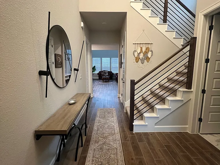 Bright and welcoming entryway with abundant natural light and soaring high ceilings, creating an open, airy feel from the moment you walk in. A perfect first impression that sets the tone for the rest of the home.