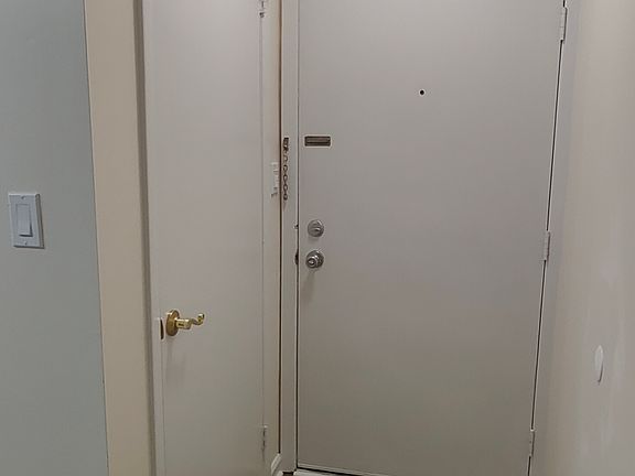 View of the entrance from the inside. Coat closet door on the left. Main door straight