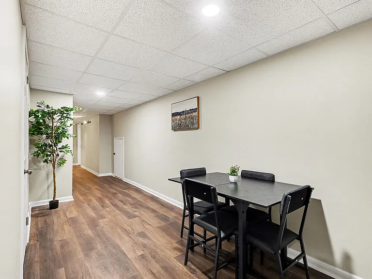 Compact dining nook with a table for four, durable wood-look flooring, and easy access to nearby rooms for everyday meals.