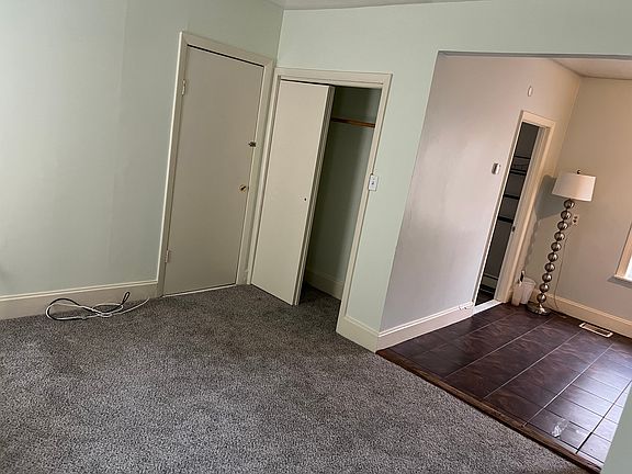 carpeted living room, with a small closet is open to the kitchen area