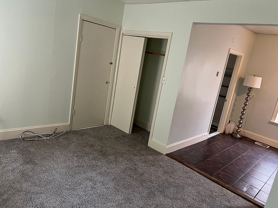 carpeted living room, with a small closet is open to the kitchen area
