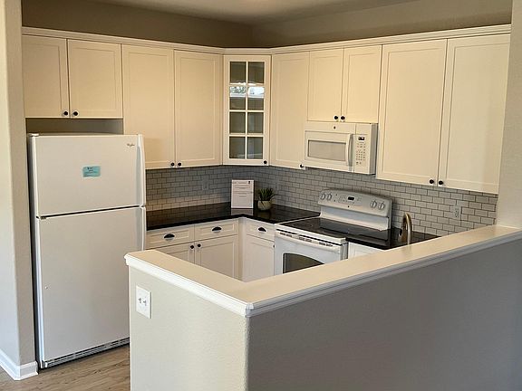 Beautiful updated white kitchen, tile backsplash, granite countertops, refrigerator has icemaker