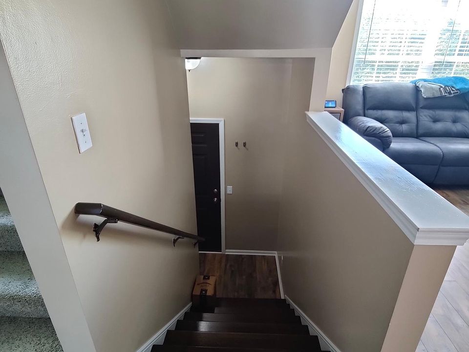 stairs from second/main floor to landing with front door (opens to the pond area)