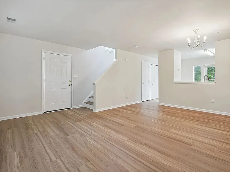 Overview of the living and dining area, entrance, connections to the kitchen, and stairs to the upper level.