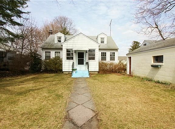 Front of the house flanked by a spacious one car garage.
