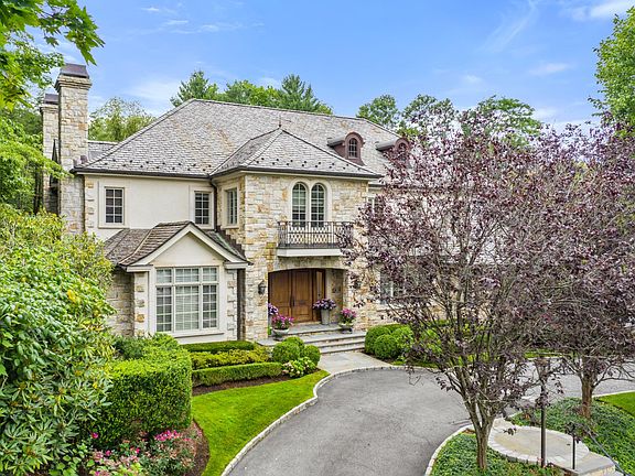 Beautiful landscaping and driveway leads to double mahogany front doors.