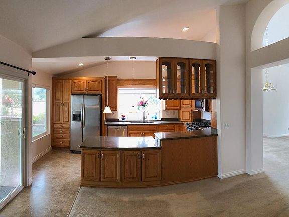 Custom built kitchen keeps cooking area separated, yet in view of family room. Table height eating area has storage area accessible to family room.