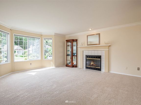 Bright living room with crown moulding, wood fireplace>