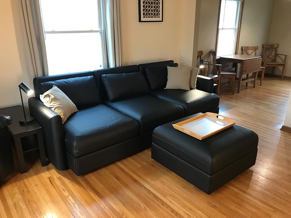 Living room. Faux-leather sleeper sofa, storage ottoman.