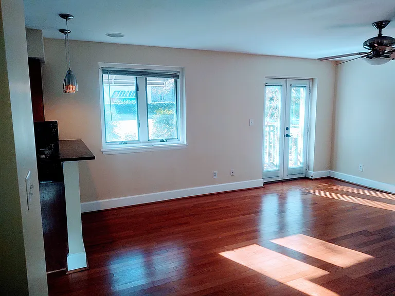 Living room opens to kitchen with bar area. French doors to the small balcony.