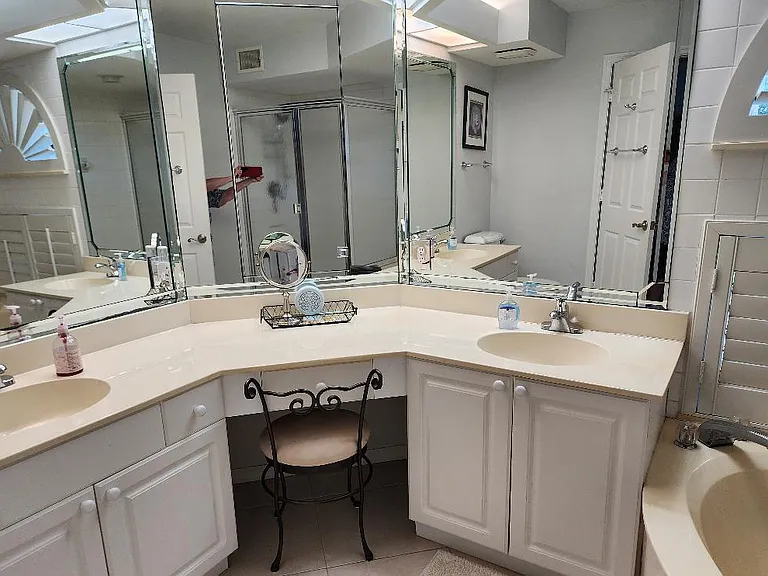 Ensuite bathroom with double sinks and vanity seating.