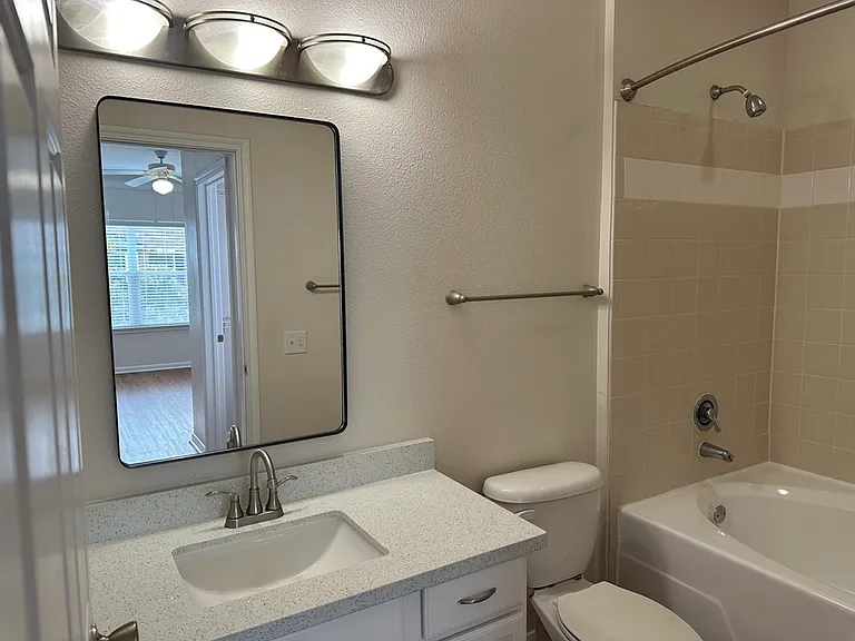 Elegant bathroom featuring a quartz countertop, modern lighting, and spacious mirror reflecting a bright room. Elegant bathroom featuring a quartz countertop, modern lighting, and spacious mirror reflecting a bright room.