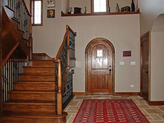 Volume Foyer, Walnut Entry Door, Trav Stone Flrs, Maple Stairs w/Iron Railings