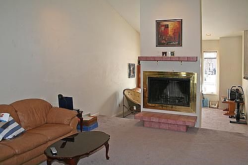 living and family rooms seperated by a woodburning fireplace