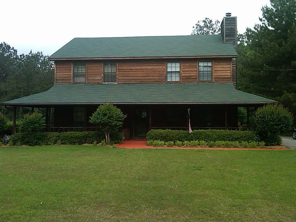 Large front porch w/ swing and ceiling fans, paved driveway w/ basketball goal