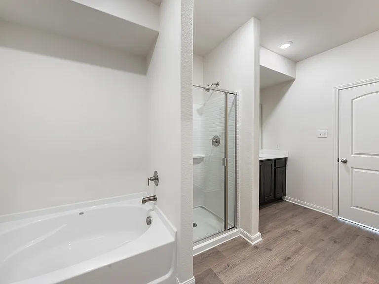 The master bathroom has a large walk-in, glass shower and a garden tub.