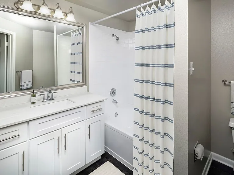 Classic Package II bath with white quartz countertop, white cabinetry, and hard-surface flooring