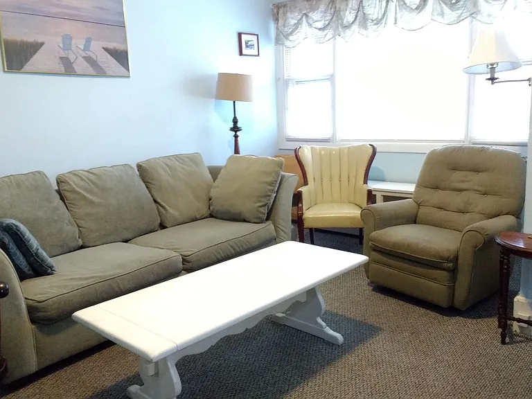 Living room area. Windows overlook front porch.