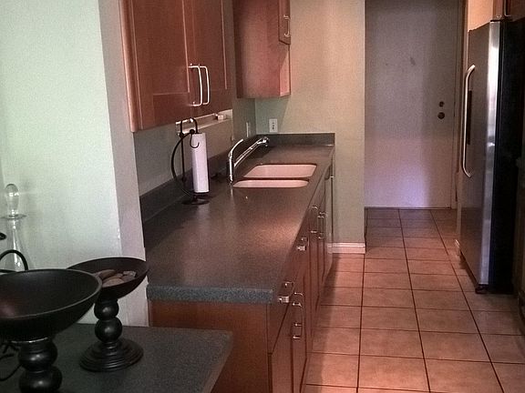 Kitchen side view toward front door. Oven, stove, microwave to right.