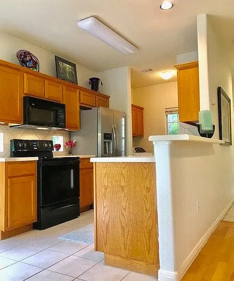 Windows under cabinets to allow nature to flow inside and large window in utility area. Refrigerator does not convey.