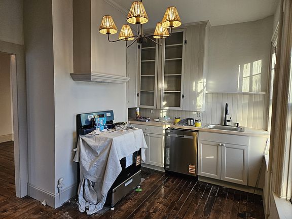 Kitchen has original built-in cabinets, concealed custom range hood and brand new gas stove, along with brand new dishwasher