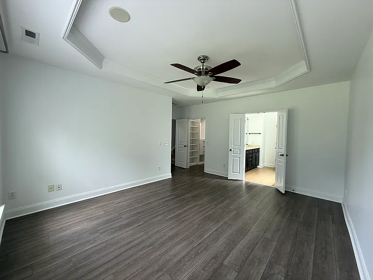 Massive master suite with a private layout, offering double French doors that open directly into an en-suite bathroom and the custom walk-in closet."