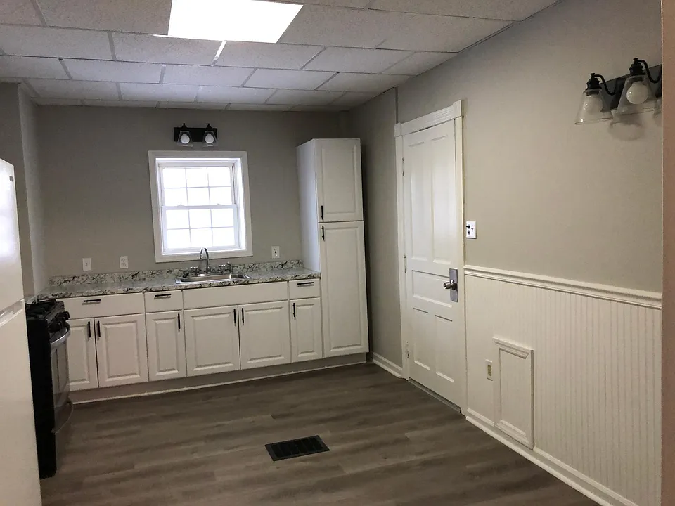 Shelves going up alongside windows. Cabinets and pantry are new. Door accesses a mud room for extra storage