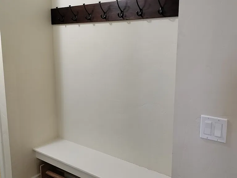 Laundry room with new LG washer/dryer (20+ settings), ample counters, and cabinets for organization. Conveniently located by the garage, with benches, a coat rack, and a half bath_perfect for managing outdoor gear and storage needs.