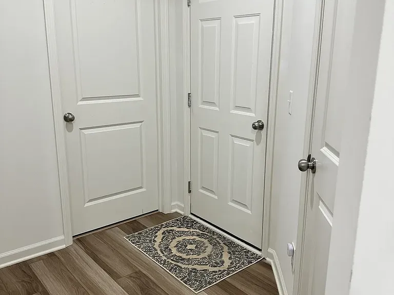 Entryway view featuring the garage access (center door), a washer and dryer with high-end appliances (left door), and additional storage space (right door).