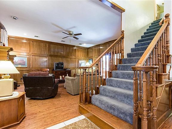 As you enter this home the living room is on the left.  To the right of the stairs is the formal dining room.  The living room has a luxury woodlike vinyl flooring which was installed June 2015.  This home features library paneling and a custom built fire