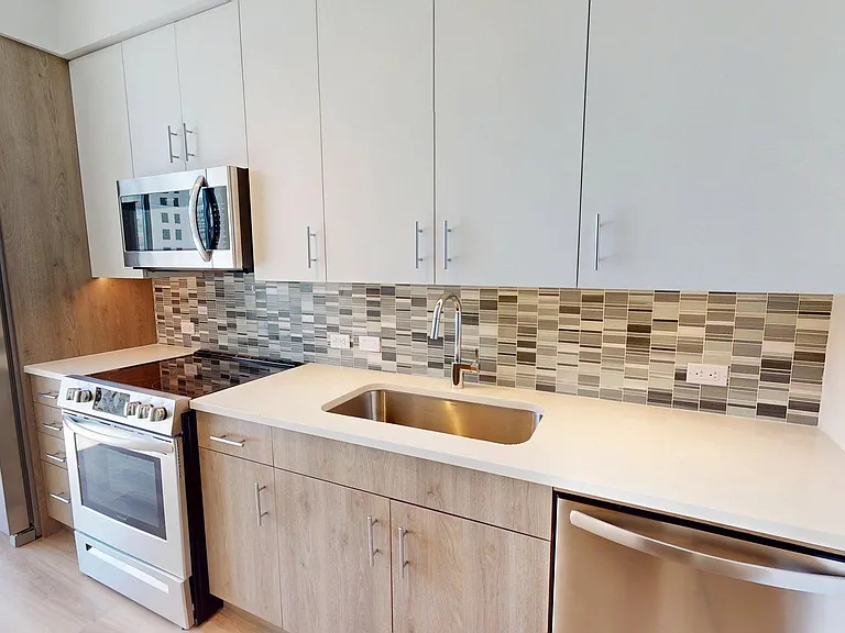 Apartment Kitchen with Quartz counter tops and Wood Style Flooring.
