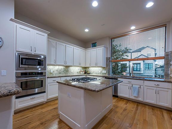 Large, bright, island kitchen with serving bar to dining area