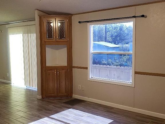 Living room view as you enter the mobile home. Two large windows on opposite sides bring in natural light.