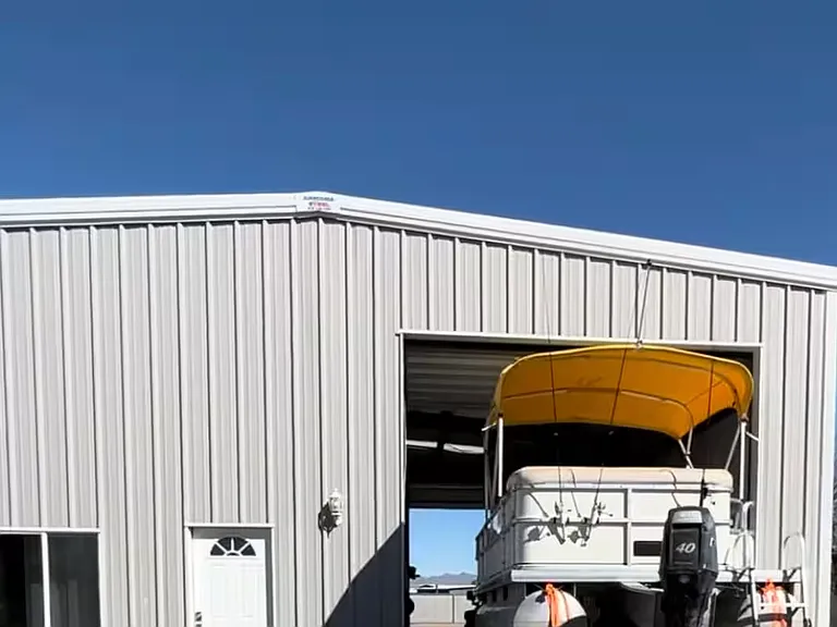 Exterior view of the oversized attached shop/garage with tall roll-up door and direct driveway access.