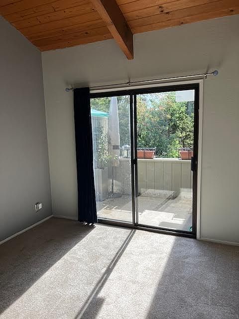 Sunny deck off bedroom with vaulted ceilings