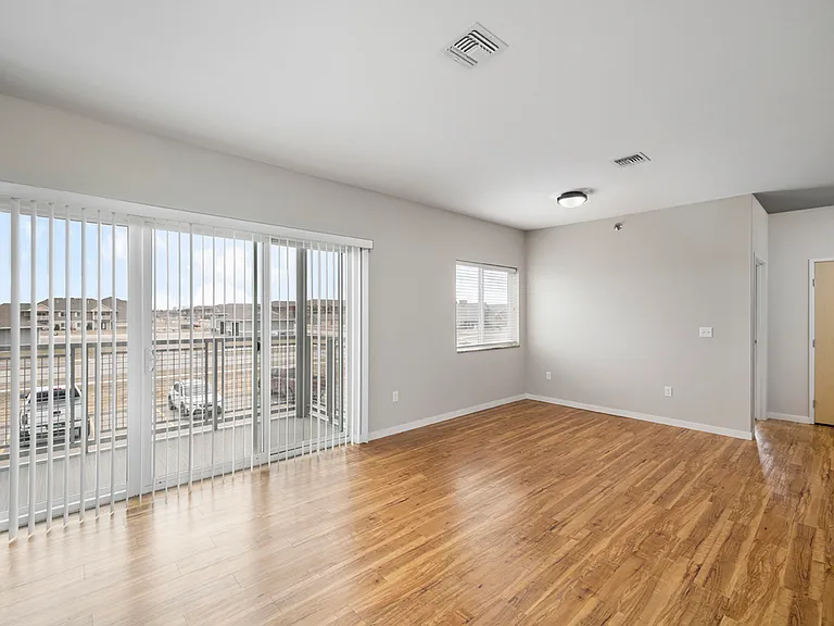Bright and airy apartment living space with large windows, sleek wooden flooring, and abundant natural light. Bright and airy apartment living space with large windows, sleek wooden flooring, and abundant natural light.