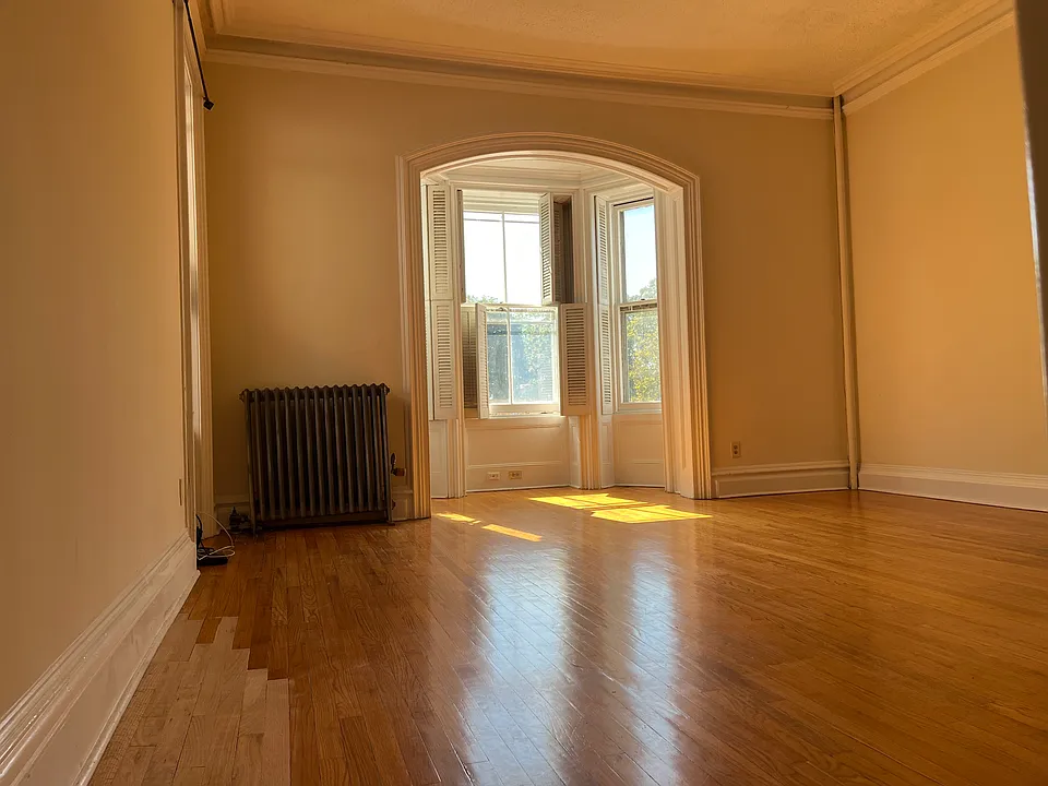 Living room with large bay windows and high ceiling
