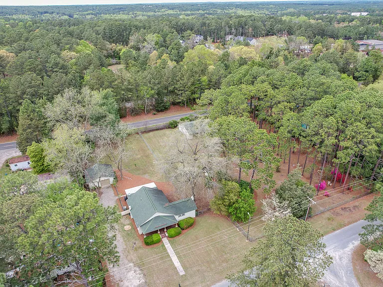 Aerial shot showing the property's huge front and back yards, plus adjacent wooded lot