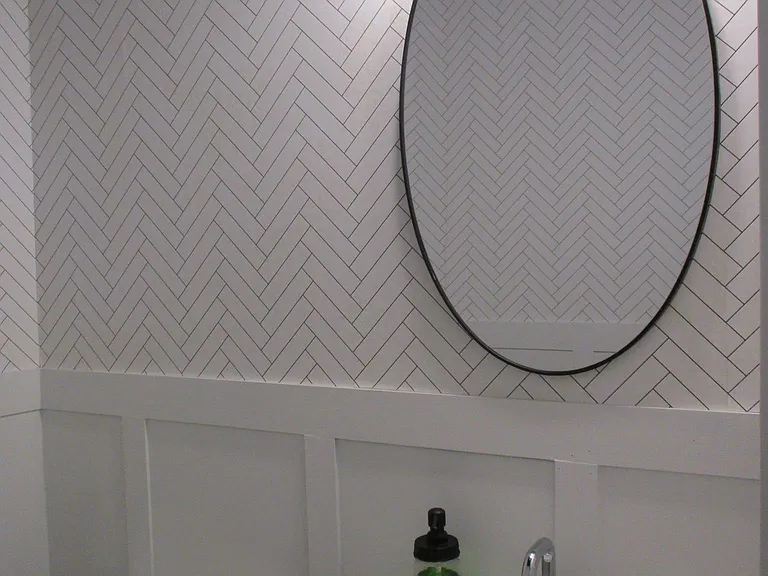 powder room downstairs with herringbone w/ wainscoting