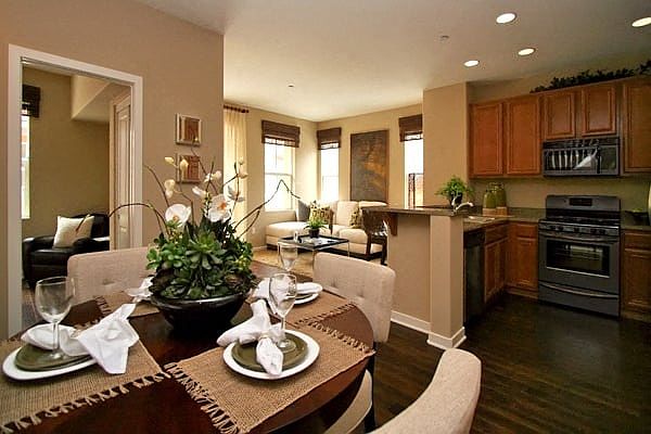 Open kitchen with gas range, microwave, dishwasher, and beautiful wood cabinets at Serenata Townhomes in San Diego, California.