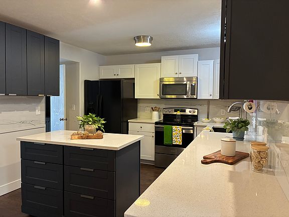 Beautiful, large quartz countertop island that moves! Pull it out for prep and tuck it away afterwards.
