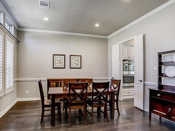 Formal dining room with access to kitchen. Notice the lovely plantation shutters.
