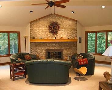Living room with  brick fireplace  and beautiful wooded views