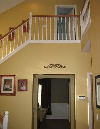 2-story foyer entry with white spindle staircase