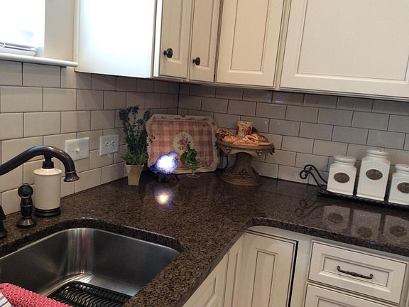 Granite counter tops with subway tile backsplash.