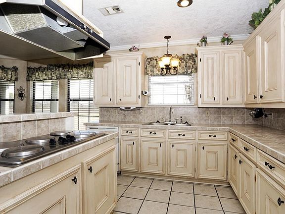 Kitchen with lots of storage space, double oven, electric range with vent, and breakfast bar.