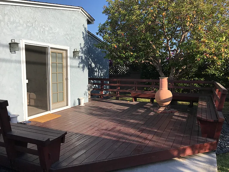 Custom-built redwood deck with seating, space for a chiminea, and a mature guava tree.