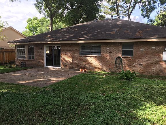 Back of house with patio.  Large trees provide great shade. 