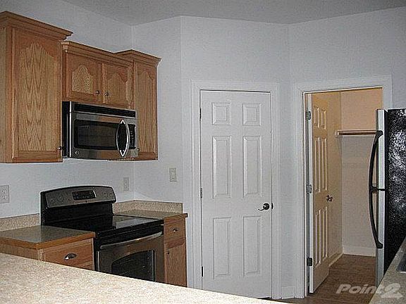 Kitchen also features smooth-top range and built-in microwave for easy meals. Closed door is to pantry closet. Through other door is laundry room and garage.