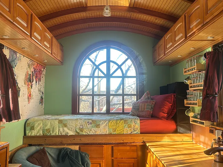 The Lucky Penny is illuminated by a skylight, giant windows, and little wafer lights under the cabinets. A window seat pulls out over the countertop, transforming into a double bed.